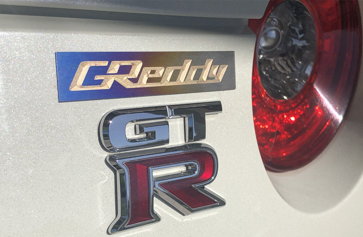 GReddy Optional Titanium GReddy Emblem - (105x20mm)