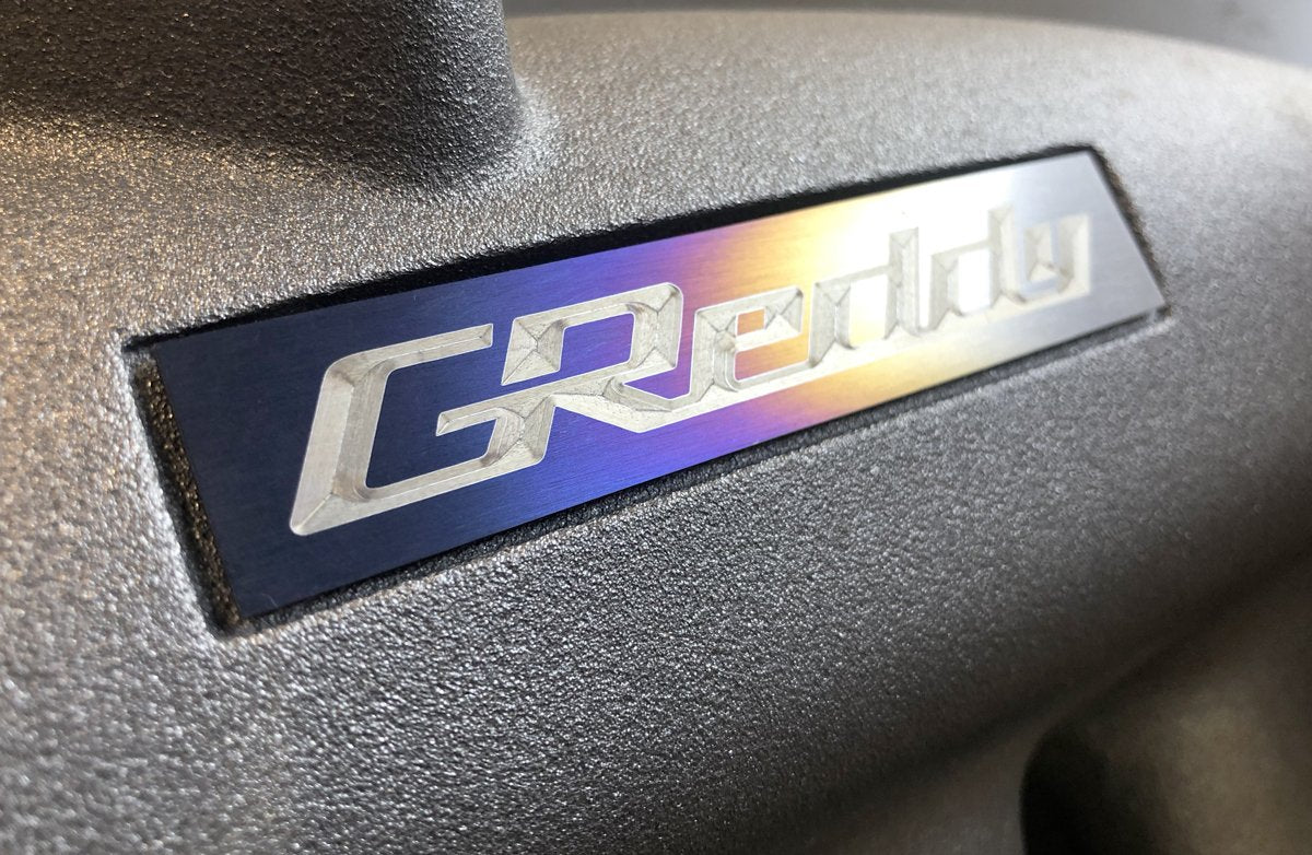 GReddy Optional Titanium GReddy Emblem - (105x20mm)