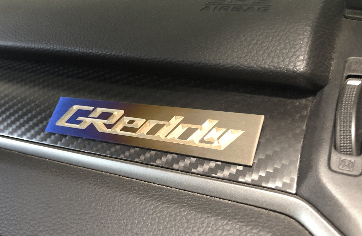 GReddy Optional Titanium GReddy Emblem - (105x20mm)